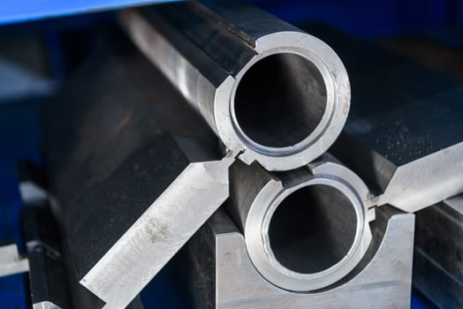 pipes, metal pieces and various metal parts for a CNC machine standing on a shelf photo