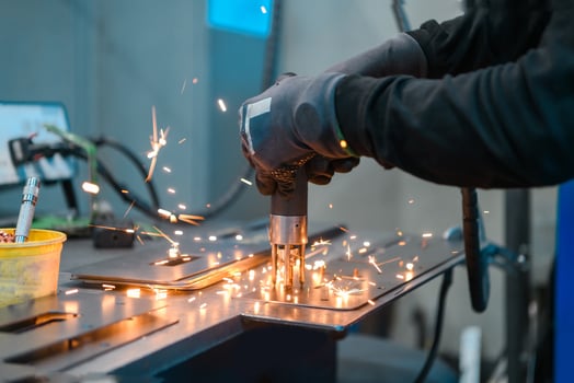 a woman working in the modern metal production and processing industry welds the product and prepares it for a cnc machine photo