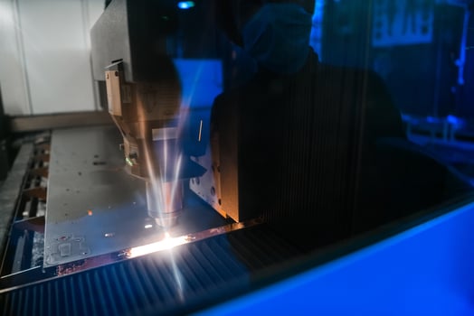 Sparks fly out machine head for metal processing laser metal on metallurgical plant background. Manufacturing finished parts for automotive production concept photo
