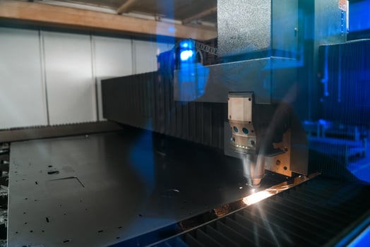 Sparks fly out machine head for metal processing laser metal on metallurgical plant background. Manufacturing finished parts for automotive production concept photo