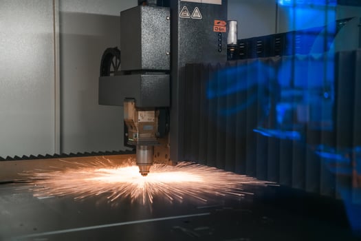 Sparks fly out machine head for metal processing laser metal on metallurgical plant background. Manufacturing finished parts for automotive production concept photo