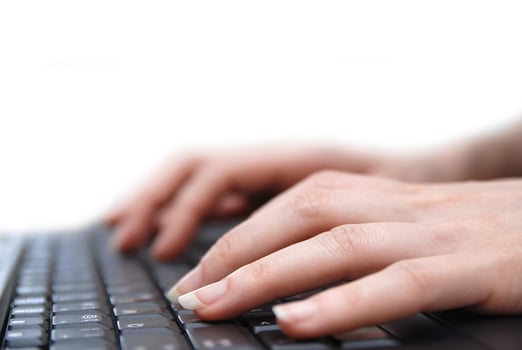 Isolated female hand typing on laptop keyboard photo