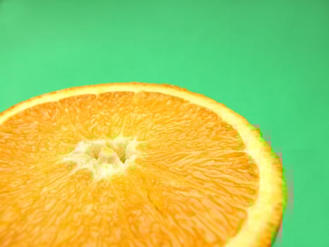 sliced orange macro on green background photo