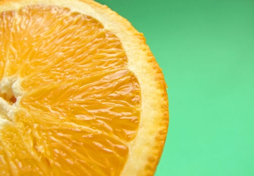 sliced orange macro on green background photo