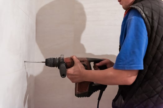 construction worker drilling holes in the bathroom photo