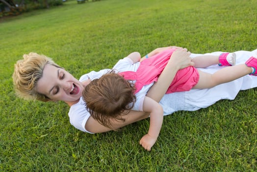 mother and little daughter playing at backyard photo