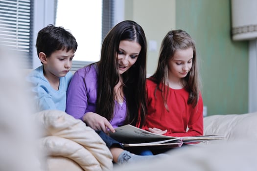 young mom play with their kids at home and reading book photo