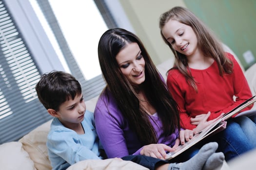 young mom play with their kids at home and reading book photo