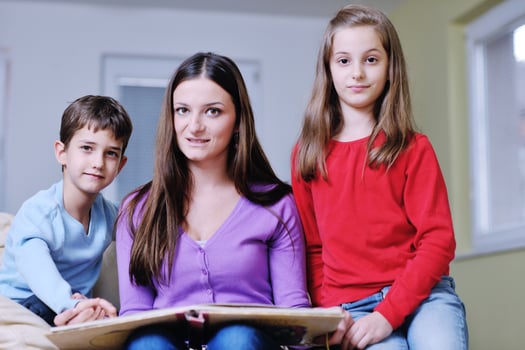 young mom play with their kids at home and reading book photo