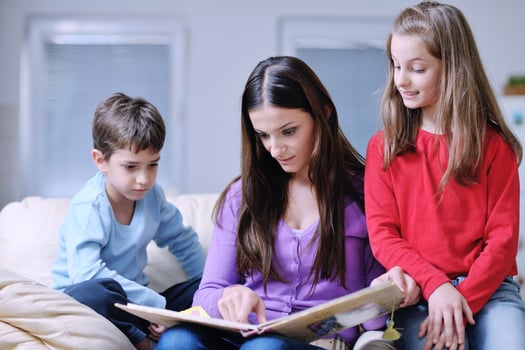 young mom play with their kids at home and reading book photo