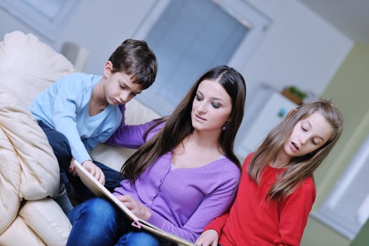young mom play with their kids at home and reading book photo