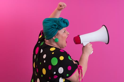 Funny plus size woman woman girl posing isolated on pastel pink wall background studio portrait. People sincere emotions lifestyle concept. Mock up copy space. Screaming in megaphone. photo