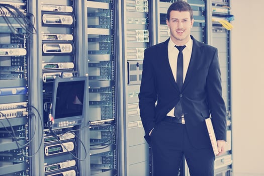 young engeneer in datacenter server room photo