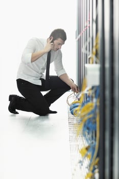 it engeneer talking by phone at network room photo