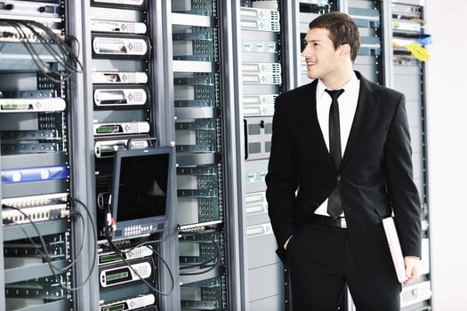 businessman with laptop in network server room photo