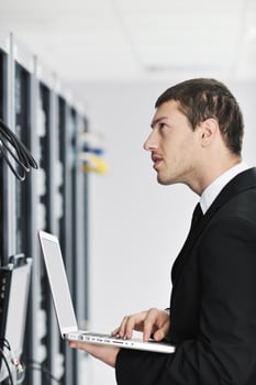 businessman with laptop in network server room photo