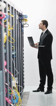 businessman with laptop in network server room photo
