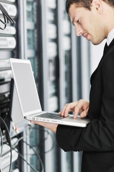 businessman with laptop in network server room photo