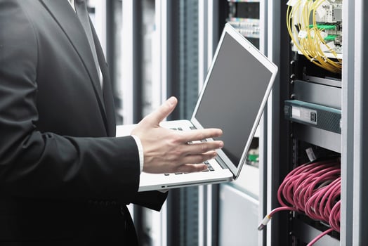businessman with laptop in network server room photo