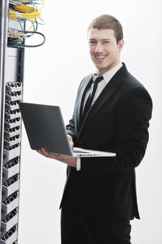 businessman with laptop in network server room photo