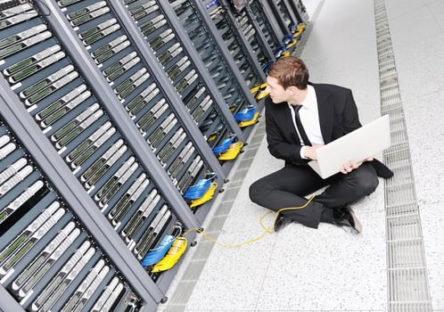 businessman with laptop in network server room photo
