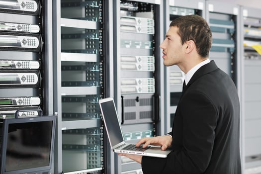 businessman with laptop in network server room photo