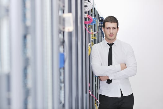 young engeneer in datacenter server room photo