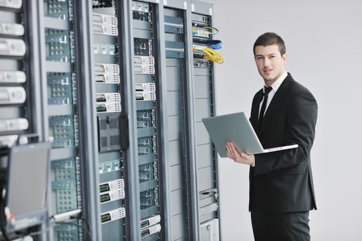 businessman with laptop in network server room photo