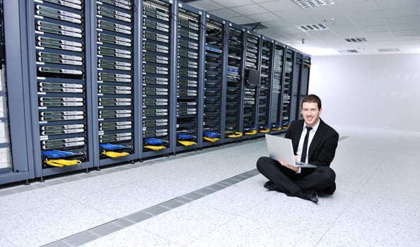 businessman with laptop in network server room photo
