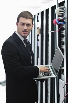 businessman with laptop in network server room photo