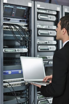 businessman with laptop in network server room photo