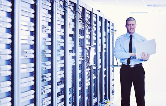businessman with laptop in network server room photo