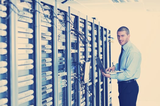 businessman with laptop in network server room photo