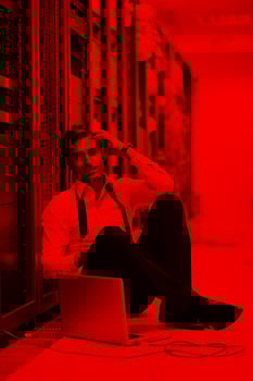 businessman with laptop in network server room photo