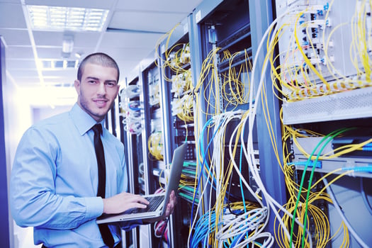 businessman with laptop in network server room photo