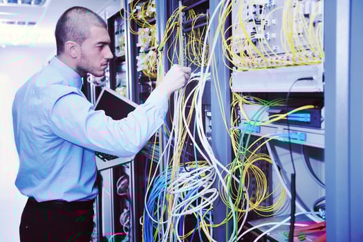 businessman with laptop in network server room photo