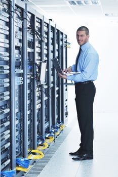 businessman with laptop in network server room photo