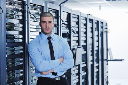 businessman with laptop in network server room photo