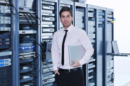 businessman with laptop in network server room photo