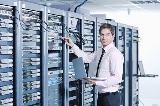 businessman with laptop in network server room photo