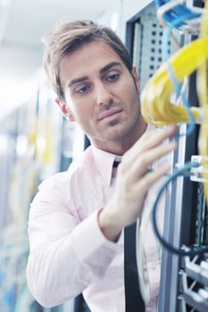 businessman with laptop in network server room photo