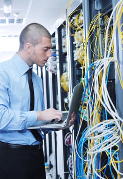 businessman with laptop in network server room photo