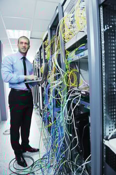businessman with laptop in network server room photo