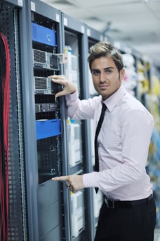 young it engineer in datacenter server room photo