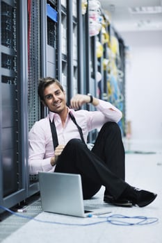 businessman with laptop in network server room photo