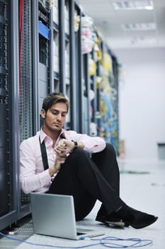 businessman with laptop in network server room photo