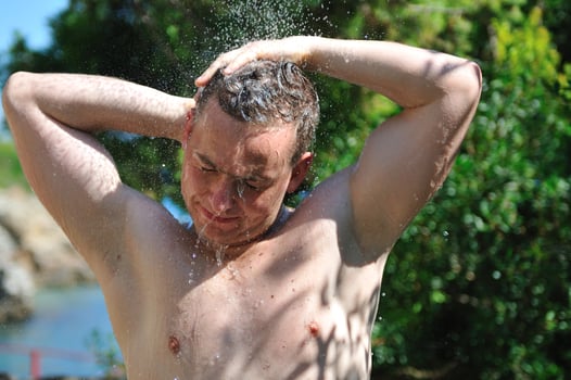 young man relaxing under shower photo