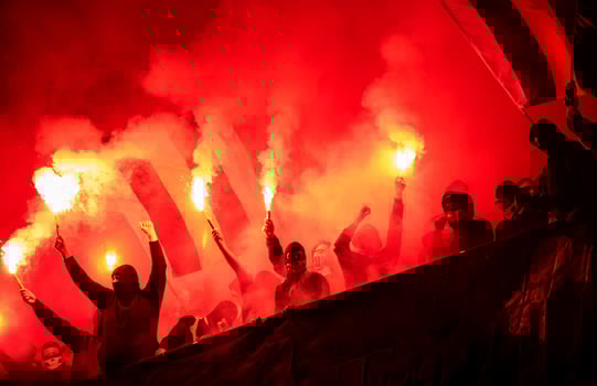 football hooligans with mask holding torches in fire photo