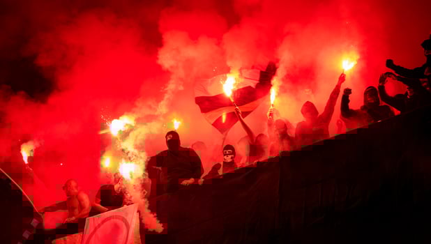 football hooligans with mask holding torches in fire photo
