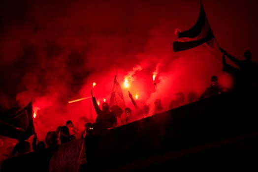 football hooligans with mask holding torches in fire photo